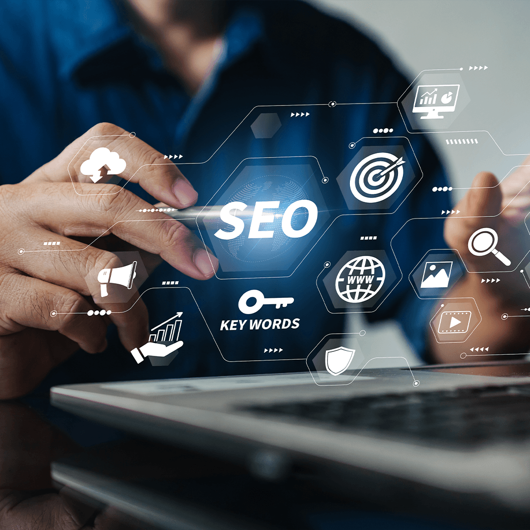 Dizüstü bilgisayar başında SEO ve anahtar kelime simgeleriyle çalışan kişi - SEO nedir, arama motoru optimizasyonu hizmeti